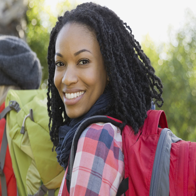 Portrait of confident woman backpacking with group