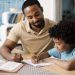 Father helping son (7-9) with homework --- Image by © Tim Pannell/Corbis